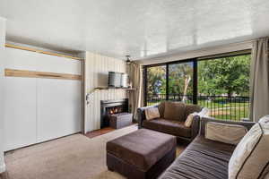 Carpeted living room with a lit fireplace and a textured ceiling