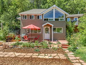 View of front of home with stucco siding and a patio