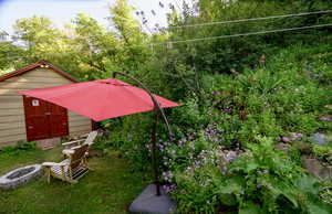 View of yard with an outdoor fire pit and a storage shed