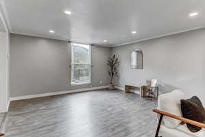 Sitting room featuring recessed lighting, wood finished floors, and ornamental molding