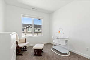 Sitting room featuring carpet flooring and baseboards