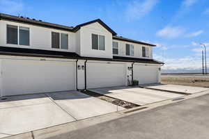 View of front facade featuring a garage and driveway