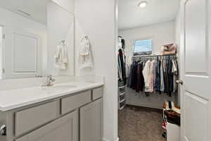 Bathroom featuring vanity and a walk in closet
