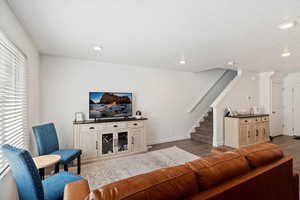 Living area featuring wood finished floors, stairway, and recessed lighting