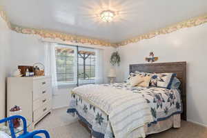 Bedroom featuring light carpet