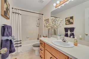 Full bathroom with vanity, shower / bath combo, and tile patterned floors