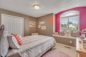 Bedroom with a textured ceiling, a closet, and carpet flooring