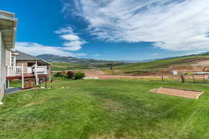 View of yard with a deck with mountain view and a rural view