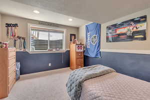 Carpeted bedroom featuring recessed lighting and a textured ceiling