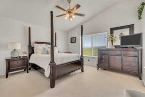 Bedroom with light colored carpet, a ceiling fan, and high vaulted ceiling