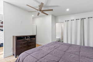 Bedroom with wood finished floors, recessed lighting, a ceiling fan, and ensuite bath