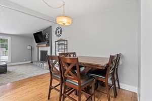 Dining area featuring a stone fireplace and light wood-type flooring