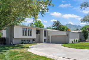Split foyer home with a mountain view, driveway, a front lawn, and a garage