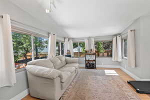 Sunroom with wood finished floors and baseboards