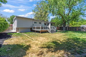 Back of house with a fenced backyard and a wooden deck
