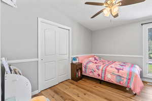 Bedroom featuring wood finished floors, a textured ceiling, and a ceiling fan