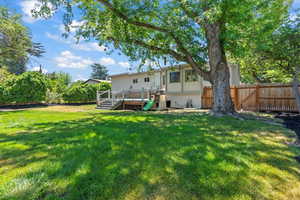 Rear view of house with a deck and a fenced backyard