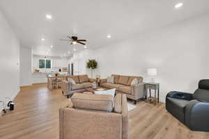 Living room with a ceiling fan, recessed lighting, and light wood-type flooring