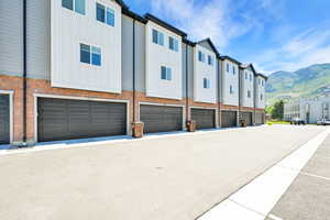 View of property featuring a mountain view, an attached garage, and a residential view