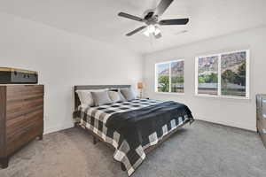 Carpeted bedroom with a textured ceiling and a ceiling fan