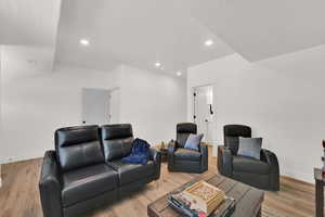 Living area with light wood-style floors and recessed lighting