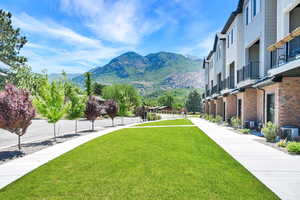 View of home's community with a mountain view and a lawn