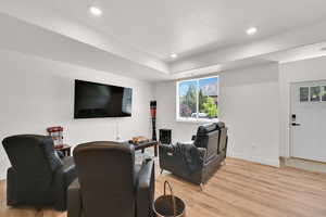 Home theater room with light wood-style flooring and recessed lighting