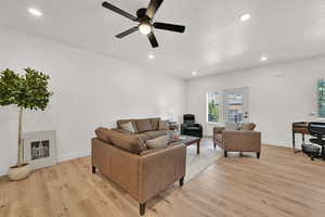 Living area with light wood-style flooring, a ceiling fan, and recessed lighting