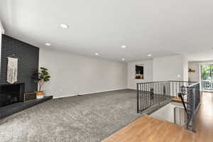 Living room featuring recessed lighting, a fireplace, and carpet floors