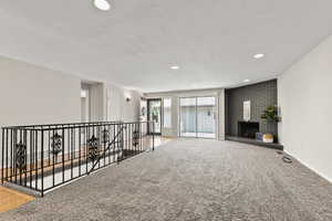 Living room with a textured ceiling, a fireplace, and recessed lighting