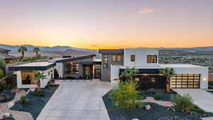 Contemporary home with a mountain view, concrete driveway, stucco siding, and a garage