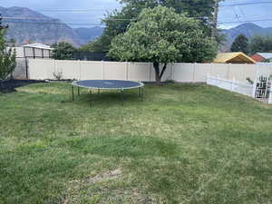 Fenced backyard featuring a mountain view