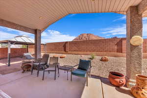 Fenced backyard featuring a gazebo and a patio area