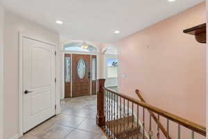 Entrance foyer featuring arched walkways, recessed lighting, and light tile patterned floors