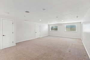 Empty room with light colored carpet, a smoke detector, and recessed lighting