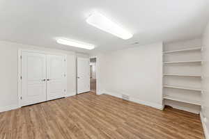 Unfurnished bedroom featuring wood finished floors and a closet