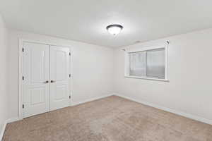 Unfurnished bedroom featuring carpet floors and a closet