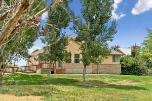 View of front of property featuring a front lawn and brick siding