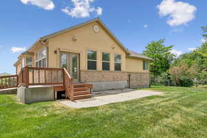 Rear view of house with stucco siding, french doors, and a patio