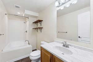 Full bath with shower / bath combination, vanity, and wood finished floors
