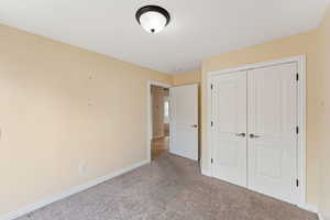 Unfurnished bedroom featuring carpet floors and a closet