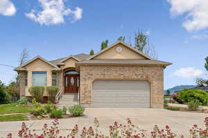 Single story home with concrete driveway, an attached garage, stucco siding, and brick siding