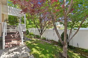 Fenced backyard featuring a pergola