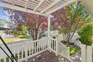 Deck with a fenced backyard and a pergola
