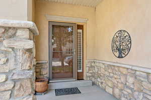 View of exterior entry with stone siding and stucco siding
