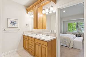 Bathroom with double vanity, tile patterned floors, and ensuite bathroom