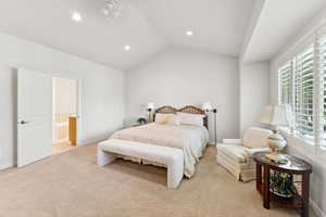 Bedroom featuring multiple windows, light carpet, recessed lighting, lofted ceiling, and ensuite bathroom