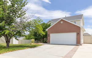 View of side of home featuring brick siding, driveway, an attached garage, and a shingled roof