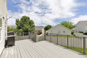 Wooden deck with area for grilling, a residential view, and a fenced backyard