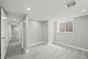 Below grade area featuring carpet floors, a textured ceiling, and recessed lighting